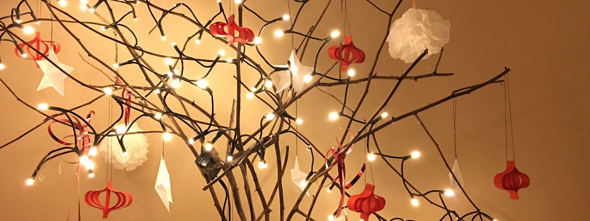 Świąteczne drzewko przystrojone lampkami i ozdobami z papieru