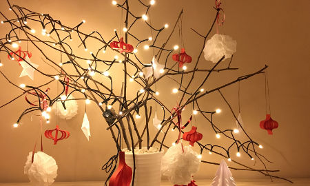 Świąteczne drzewko przystrojone lampkami i ozdobami z papieru